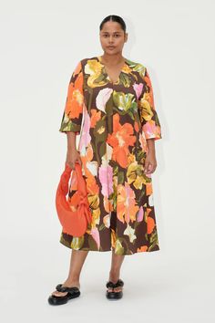 Step into a world of vibrant elegance with the Vic Dress by Stine Goya. This eye-catching piece features an oversized, mid-length silhouette, perfect for making a statement. Oversized Orange Dresses For Spring, Bold Dresses For Spring Vacation, Oversized Floral Print Dress For Daywear, Oversized V-neck Floral Print Dress, Bold Multicolor Spring Dresses, Designer Hair Accessories, Stine Goya, Exclusive Dress, Flowing Skirt