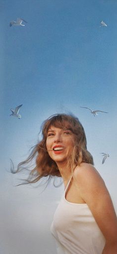 a woman with long hair standing in front of seagulls flying above her head