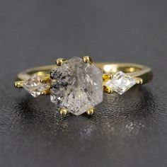 a yellow gold ring with three diamonds on it