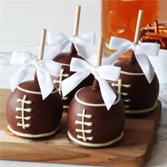 chocolate covered candies with white bows are on a cutting board