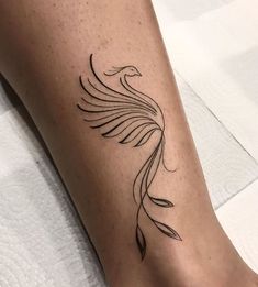 a tattoo on the leg of a woman with a bird design on it's side