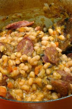 a pot filled with beans and meat on top of a stove