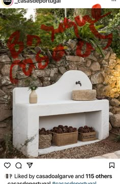 an outdoor fireplace with pots and baskets on the shelf next to it, surrounded by stone walls