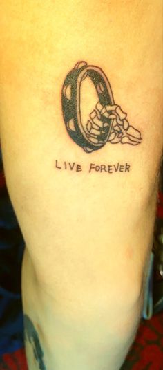 a person with a tattoo on their leg that says live forever