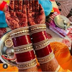 two hands that are covered in henna and bracelets on top of each other