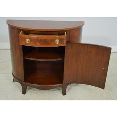 an oval shaped wooden cabinet with two drawers