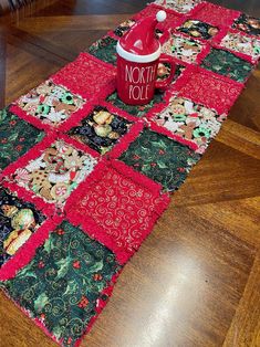 a red coffee cup sitting on top of a table next to a christmas themed place mat