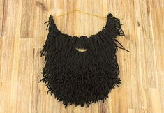 a man's black beard is hanging on a wooden floor