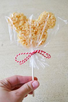 a hand holding a lollipop with candy canes in it's wrapper