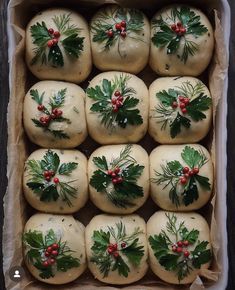 christmas sprigs and holly decorated rolls in a baking pan with parchment paper on the side