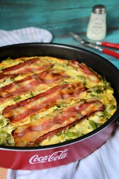 a close up of a pizza in a pan with bacon and cheese on the top