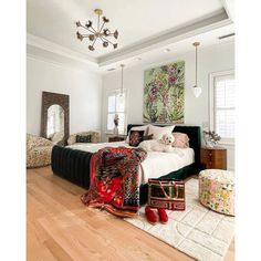 a bedroom with white walls, wood floors and a large bed in the middle of the room