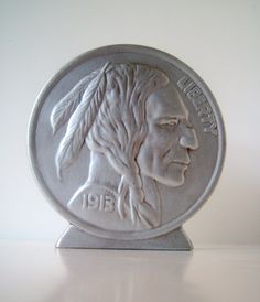 a silver coin with a man's face on it sitting on a white surface