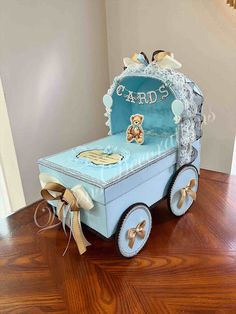 a blue cart with a teddy bear on the front and sides, sitting on top of a hard wood floor