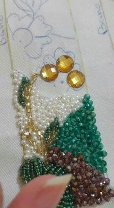 someone is stitching beads on to a piece of fabric