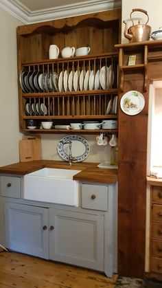 a kitchen with wooden cabinets and white dishes