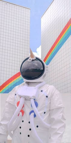 a man in an astronaut suit with a bird on his head and two buildings behind him