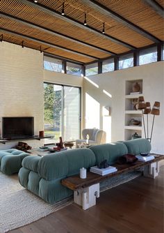 a living room filled with furniture and a fire place in front of a large window