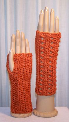 an orange crocheted arm warmer on top of a white mannequin head