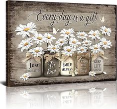 three mason jars with daisies in them and the words every day is a gift