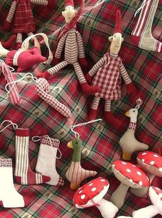 christmas ornaments are displayed on a plaid cloth with red and white decorations hanging from them