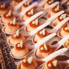 small desserts are lined up on trays with spoons in the shape of hearts