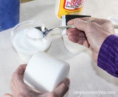 a person is using a spoon to dip marshmallows