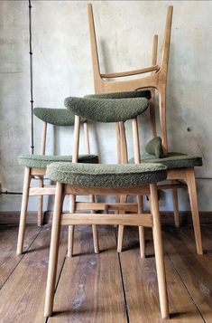 three chairs stacked on top of each other in a room with wooden floors and walls