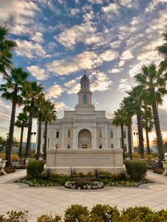 a large white building surrounded by palm trees