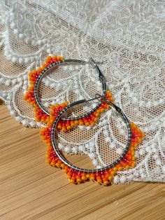 Hand beaded hoop earrings.  Hinge closure. Hoop measures approximately 1.5" wide. Nickel-free Adjustable Hoop Beaded Earrings, Nickel-free Small Hoop Beaded Earrings For Summer, Adjustable Orange Hoop Earrings, Summer Hoop Beaded Earrings, Adjustable Small Beaded Hoop Earrings, Adjustable Hypoallergenic Hoop Beaded Earrings, Summer Festival Beaded Hoop Earrings, Adjustable Hypoallergenic Beaded Hoop Earrings, Summer Orange Hoop Jewelry