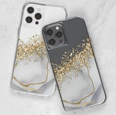 two iphone cases with gold glitter on them sitting next to each other in front of a white background