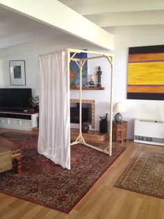 a living room filled with furniture and a white canopy over the fire place on top of a rug