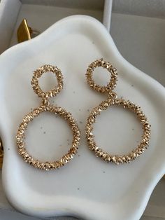 ✨Indulge in the ultimate expression of luxury with our Elsa Gold Earrings. ✨These captivating pieces feature a double-hoop design, intricately textured to catch the light from every angle. ✨Bold yet elegant, they exude a sultry sophistication that elevates any look. ✨Perfect for those who demand attention and embrace their inner radiance, the Elsa earrings are more than just an accessory—they're a statement. Let your allure shine through with every wear. Elegant Circular Metal Earrings, Elegant Circle Metal Earrings, Elegant Textured Jewelry For Party, Elegant Textured Metal Earrings, Circular Metal Party Earrings, Elegant Textured Jewelry For Anniversary, Pierced Circular Party Earrings, Metal Circle Earrings For Anniversary, Elegant Textured Gold-plated Jewelry