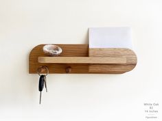 a wooden shelf holding keys and a piece of paper