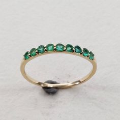 **KINDLY CHECK OUT THE VIDEO OF THE ITEM FOR A CLEARER VIEW**Details of the ring Gem: Emerald Gem size: 2 mm (9 pec ) Gem shape-Round Gem weight: 0.26 carats Gold purity: 14KT (58.33% approx.) Gold weight: 0.86 gms Total weight of ring:0.91 gms Ring size us 6 Diamond cut Natural Emerald Gemstones set in Solid 14KT Yellow Gold. The Gold purity is guaranteed and it comes with authentic 14 kt gold hallmark. Since these Rings are handmade, Size Customization is available for this ring and it is avai Emerald Half Eternity Ring For May Birthstone, May Birthstone Emerald Ring With Half Eternity, Fine Jewelry Emerald Ring With Half Eternity Band, Round Half Eternity Emerald Ring In Fine Jewelry Style, Emerald Half Eternity Band With Round Shape, Round Emerald Half Eternity Band, Emerald Half Eternity Band, Emerald Bridesmaids, Birthstone Wedding Ring