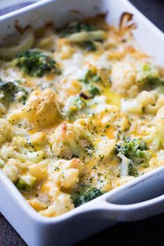 a casserole dish with broccoli, cheese and other items in it