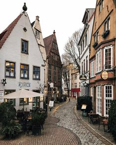 a person riding a bike down a cobblestone street in an old european town