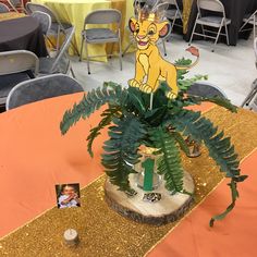 there is a plant on top of the table with a lion cut out next to it