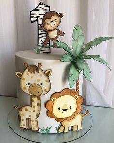 a birthday cake decorated with animals and a number one