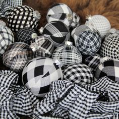 black and white plaid fabric balls are piled on top of each other in a pile