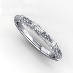 a white gold wedding ring with diamonds on the sides and an intricate design in the middle