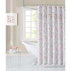 a white bath tub sitting next to a window with a curtain in front of it