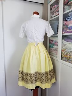 "Sweet little summery skirt! This is made with a buttery yellow textured weave cotton fabric. The skirt is pleated to a flat waistband, and there is a cute border in brown with surface embroidery with hearts. I think it was all hand done! So much time went into this as I believe it to be hand done! This skirt closes in the back with a metal zipper ans a sweet little daisy / flower button! Condition: Very good! One small spot on skirt. On the inside you can see where the brown embroidery thread w Vintage Yellow Lined Skirt, Vintage Yellow Fitted Skirt, Fitted Vintage Yellow Skirt, Vintage Cotton Pleated Skirt, Vintage Pleated Cotton Skirt, Vintage Yellow Cotton Skirt, Surface Embroidery, Cute Border, Brown Embroidery