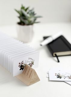 there is a stack of cards on the table next to a pen and notebooks