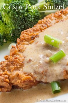 a close up of food with broccoli and gravy on the side