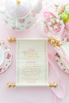 a pink and white table setting with china