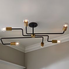 a black and gold chandelier with five lights hanging from it's ceiling