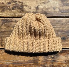 a brown knitted hat sitting on top of a wooden table