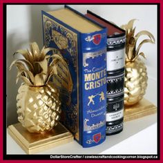 two books are sitting next to each other with gold pineapple figurines on them