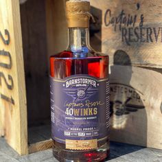 a bottle of liquor sitting on top of a wooden crate